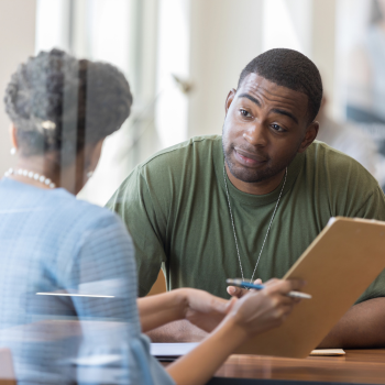 Man discussing financial documents with an advisor.